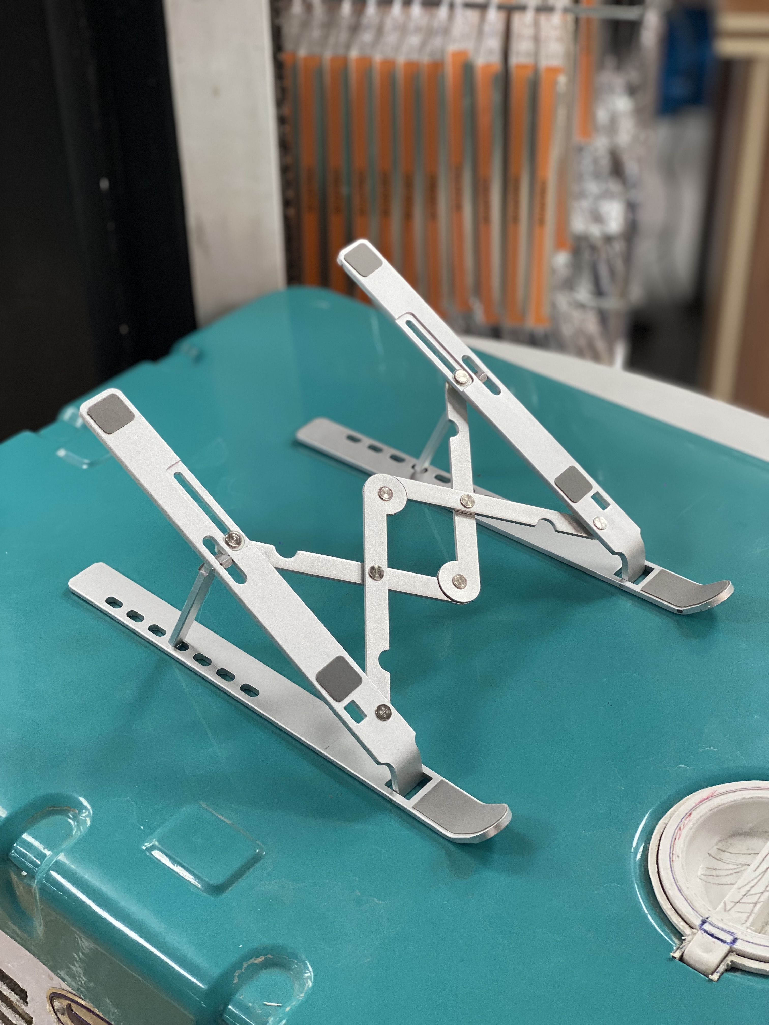 استند فلزی نقره‌ای قابل تنظیم لپ‌تاپ و تبلت روی میز کار