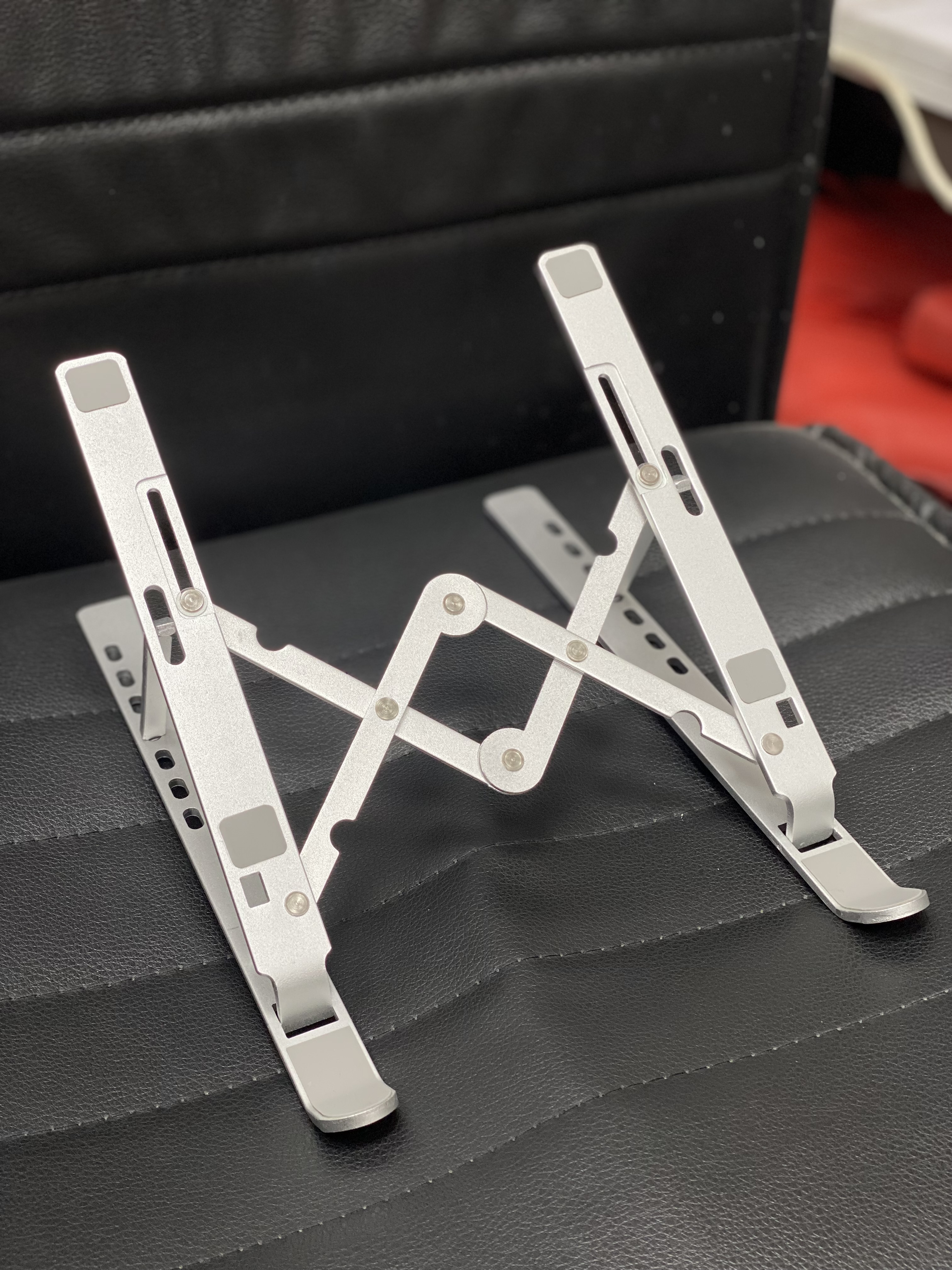 استند فلزی نقره‌ای قابل تنظیم لپ‌تاپ و تبلت روی میز کار